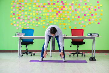 Man in the office with many conflicting priorities doing exercis