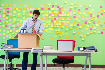 Man collecting his stuff after redundancy in the office with man