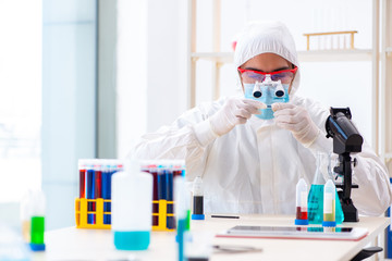 Young chemist student working in lab on chemicals