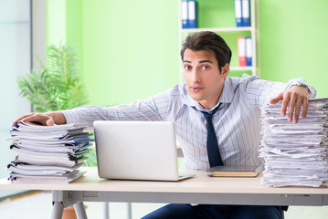 Naklejka premium Businessman having problems with paperwork and workload