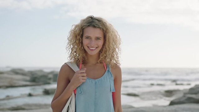 portrait of young beautiful blonde woman smiling confident on beach relaxed