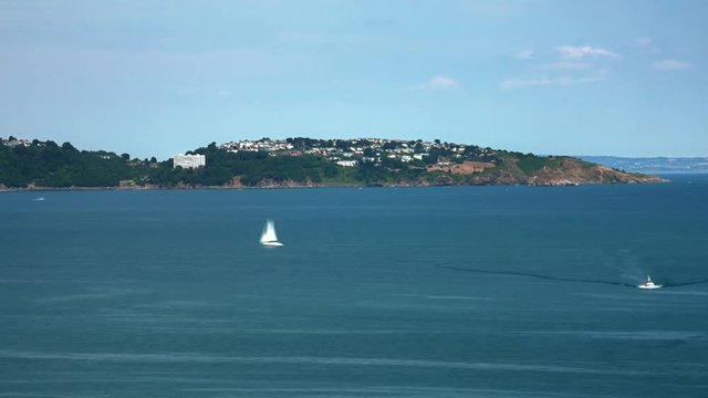 Time lapse of beach in Brixham, England. Boats racing through the water.