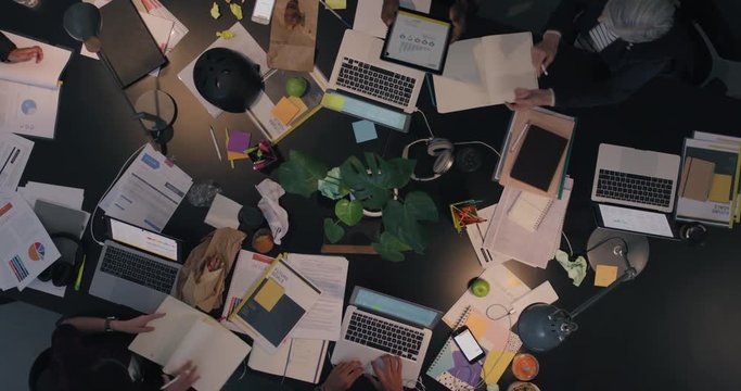 top view diverse business team working late brainstorming planning strategy for corporate project developing creative ideas in messy boardroom