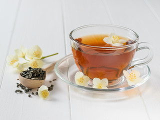 Freshly prepared tea with Jasmine flowers on a table.