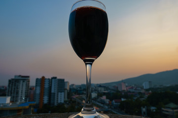A glass of red wine and the city view background, Chaing Mai, Thailand.