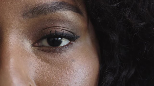 close up macro of african american woman eye blinking looking at camera 