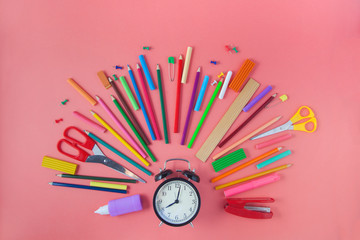 Back to school Accessories for school on a pink background Pencils Plasticine Alarm clock Briefcase Chalk Copy space Top view