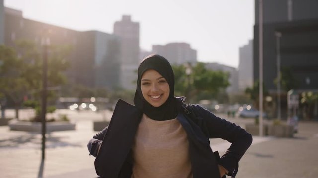 portrait of young happy muslim business woman smiling looking at camera confident wearing hajib headscarf in windy city