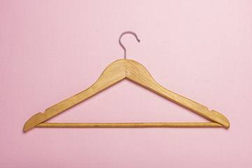 A wooden clothes hanger isolated on pink background