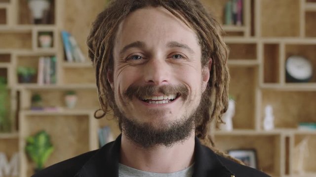 close up portrait of young attractive carefree man with dreadlocks smiling confident successful entrepreneur