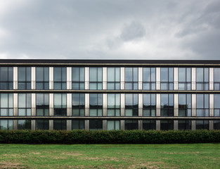 Fototapeta na wymiar Modern building facade against cloudy sky