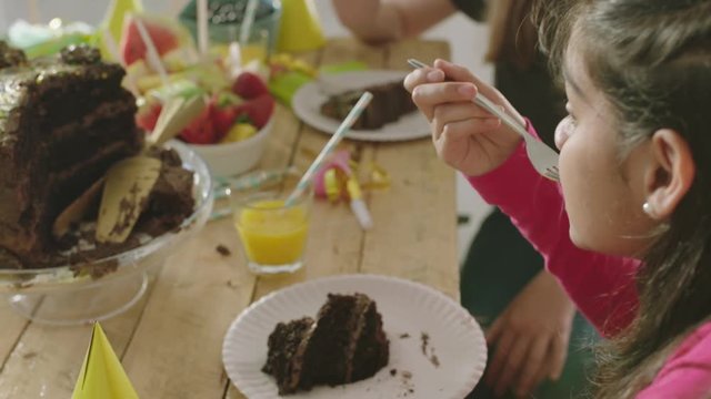 close up happy girl multi ethnic children enjoying vibrant birthday party celebration eating delicious chocolate cake
