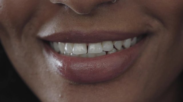 close up of african american woman glossy lips smiling happy showing healthy teeth beautiful perfect skin