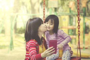 Mother and daughter play together at playground.