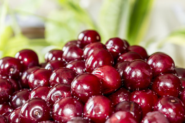 Cooking cherry jam.Wet  deep red ñherries on a background of green leaves . Site about fruits, berries , food, cuisine and cooking .