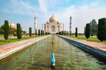 Taj Mahal front view reflected on the reflection pool, an ivory-white marble mausoleum on the south...