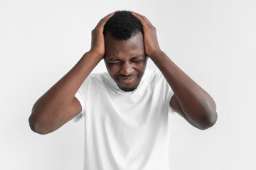 People, stress, tension and migraine concept. Upset unhappy young african american man squeezing...
