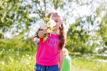 Obraz premium two small female children playing outdoors in summer on a clearing