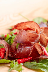 Dry beef jerky with herbs and red peppers.