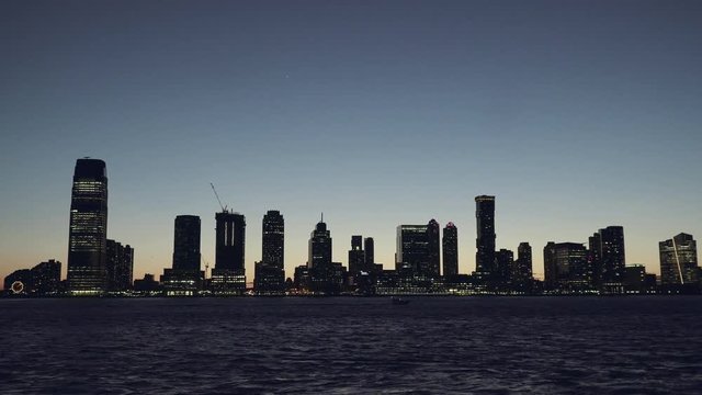 New Jersey panorama skyscrapers at evening, night, New York Skyline. Apartments and financial buildings. The skyline of New Jersey at Sunset filmed from the the Manhattan Downtown