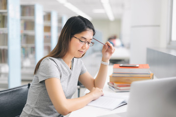 Asian Woman using laptop in the library..