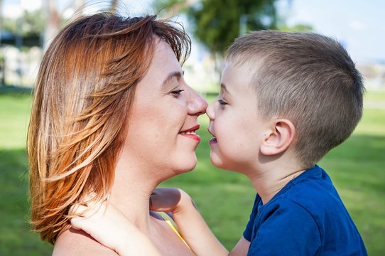 Young and beautiful Caucasian woman looking at her son, face to face close up portrait, mother child love family concept. Look at each other.