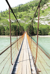 The suspension bridge over the river for a crossing.