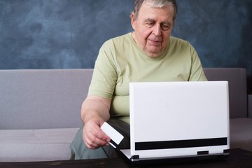 Online, shopping, internet surfing, innovation technology, happy modern retirement and people concept. Senior man with credit card doing online payment at home using laptop. 