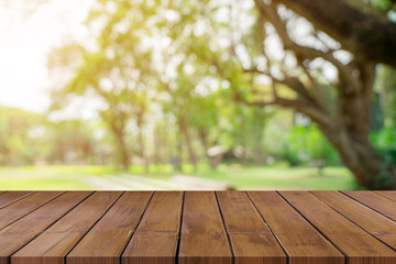 Empty wooden table top and green bokeh display montage for product with space.