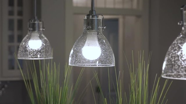Tracking shot of lights above an island in a kitchen.