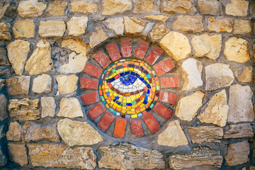 Mosaic Eye of Horus on stone wall.