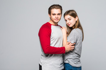Portrait of cheerful lovely cute couple hugging and holding hands, looking at each other over white background.