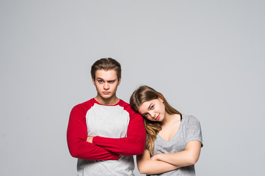 Two cheerful young teen couple with crossed hands on the white background