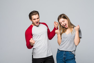 Young excited caucasian people man and woman isolated over white background make winner gesture screaming.