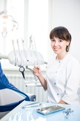 Dentist therapist in uniform sitting at the workplace