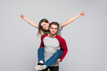 Portrait of loving couple having fun while piggyback ride isolated on white background