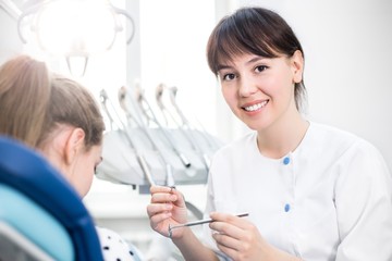 Obraz premium Dentist in uniform holding tools for dental treatment