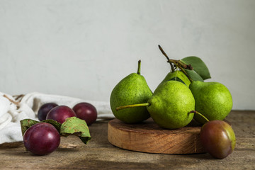 concept of the harvest of autumn and thanksgiving. Seasonal fruit pear and plum on a wooden table in rustic style with copy space