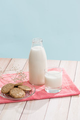 Pastry organic breakfast. Chip cookies and a glass of milk on a white wooden table.