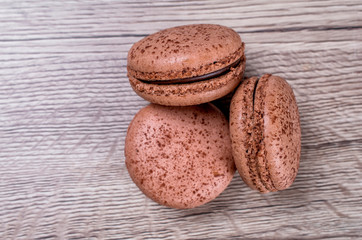 Delicious chocolate french macaroons or macaron on a wooden background whith place for insert text. Copy space