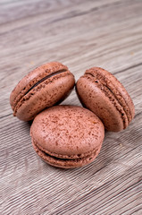 Delicious chocolate french macaroons or macaron on a wooden background