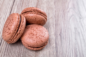 Delicious chocolate french macaroons or macaron on a wooden background whith place for insert text. Copy space