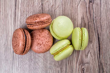 Delicious multicolored french macaroons or macaron on a wooden background