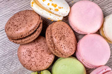 Fototapeta na wymiar Delicious multicolored french macaroons or macaron on a wooden background