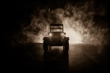 Poster Silhouet van oude vintage auto in donkere mistige getinte achtergrond met gloeiende lichten bij weinig licht. © zef art