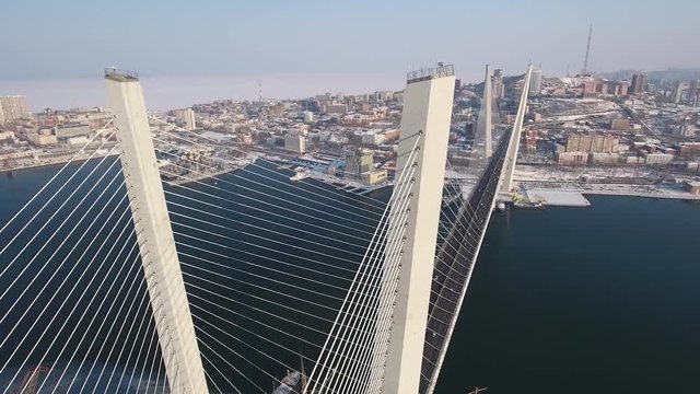 Aerial modern Golden cable-stayed bridge Close details Horn Bay Urban Winter cityscape Road traffic Port Vladivostok Asia Development architecture embankment  attraction landmark. Snow day sun. Drone