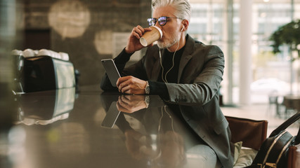 Businessman with phone drinking coffee