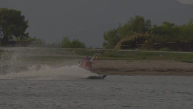 Kiteboarding at sundown doing tricks on flat water. Kite session at a sandy beach.