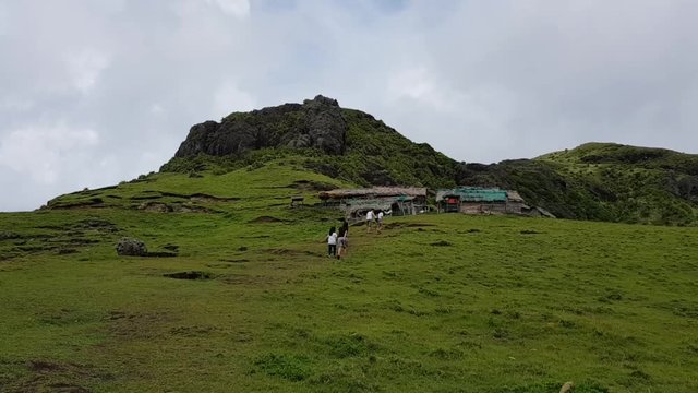 Mother and child walking or climbing up a mountainside in Batanes, Philippines.