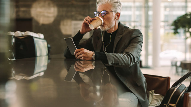 Businessman with phone drinking coffee